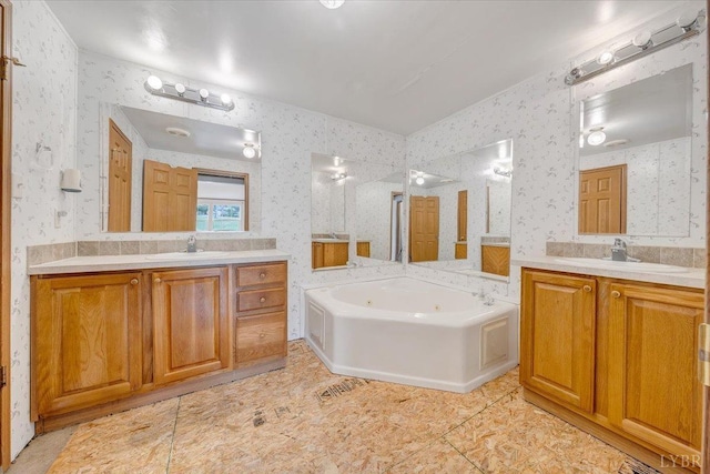 full bath with wallpapered walls, two vanities, a sink, and a whirlpool tub