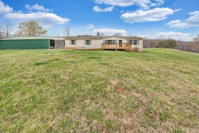 back of house with crawl space, a deck, an outdoor structure, and a lawn