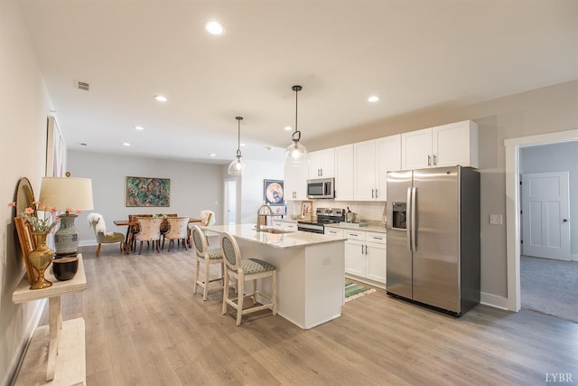 1300 Stoney Ridge Blvd Unit 206, Forest, VA 24551 - kitchen with a kitchen island with sink, visible vents, light wood-type flooring, white cabinets, and stainless steel appliances
