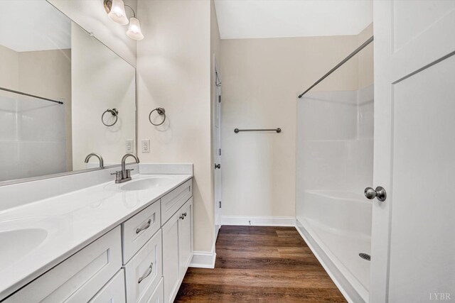 664 Collins Ferry Rd, Gladys, VA 24554 - bathroom featuring a shower, wood finished floors, double vanity, and baseboards