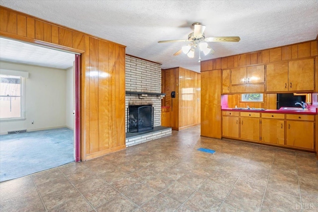 123 Knollwood Dr, Hurt, VA 24563 - kitchen with wooden walls, ceiling fan, brown cabinets, a fireplace, and a sink