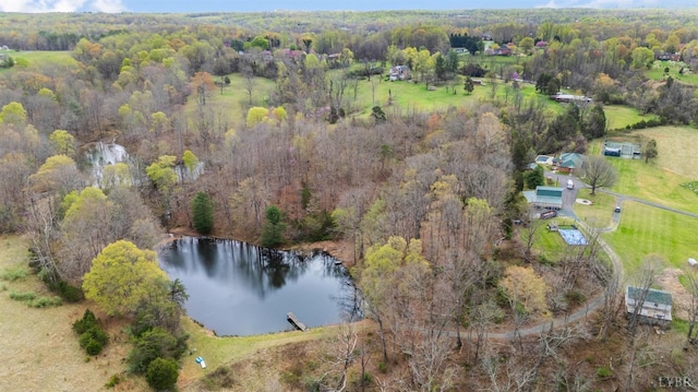 aerial view of property and surrounding area with a large body of water and a heavily wooded area