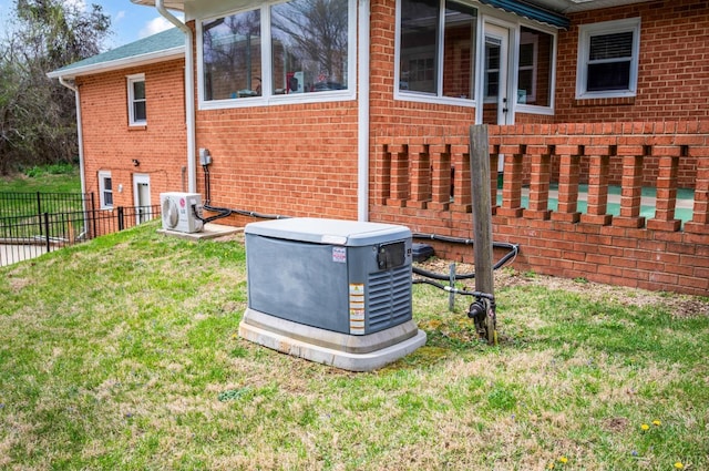exterior view of a power unit, brick siding, fence, and a cooling unit
