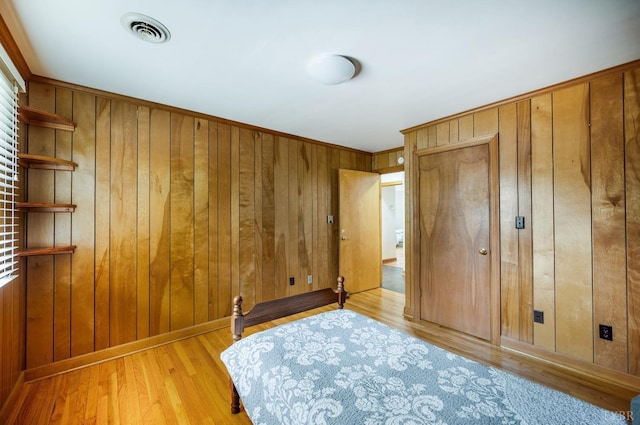 bedroom featuring wood walls and light wood-style floors