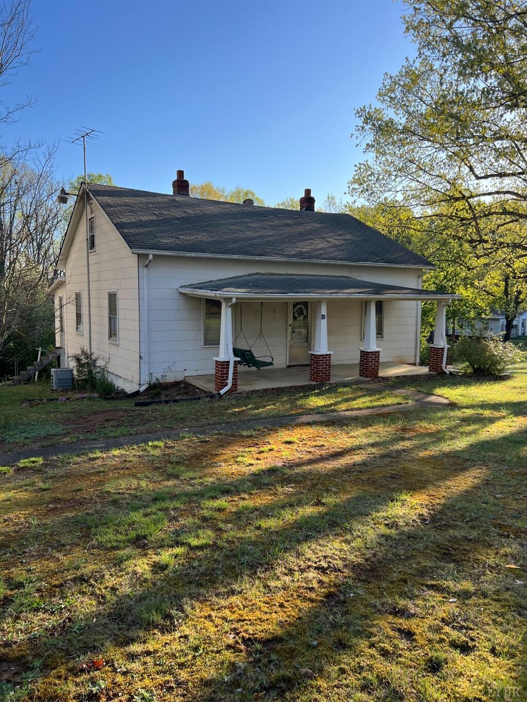 49 Bishop Creek Rd, Lynch Station, VA 24571 - view of front facade with central AC, a chimney, covered porch, a front yard, and roof with shingles