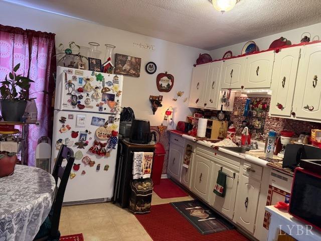 17 Westdale Dr, Lynchburg, VA 24501 - kitchen featuring white cabinets, light countertops, freestanding refrigerator, and a textured ceiling