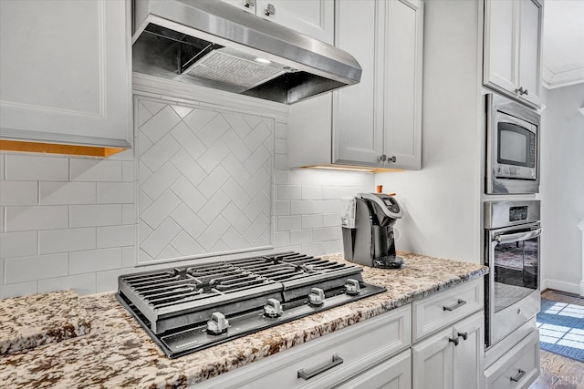 1062 Ivy Creek Dr, Forest, VA 24551 - kitchen with stainless steel appliances, under cabinet range hood, light stone counters, backsplash, and ornamental molding