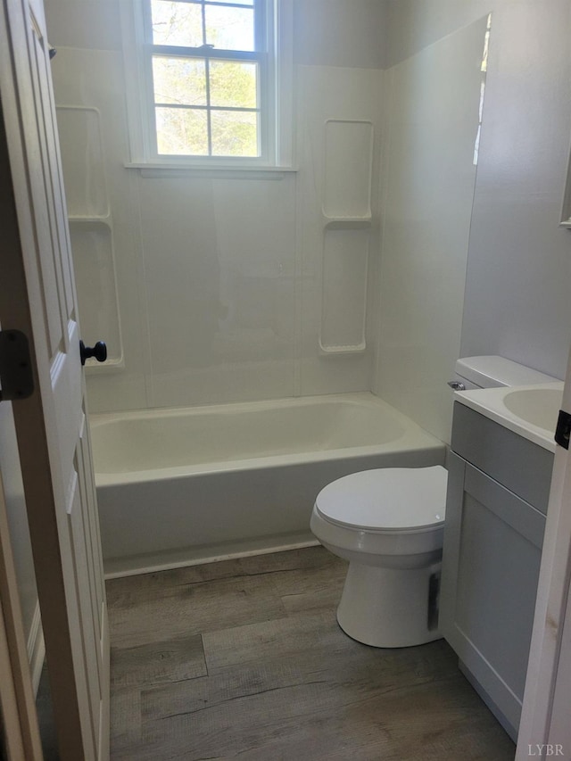 full bathroom with shower / bath combination, wood finished floors, vanity, and toilet