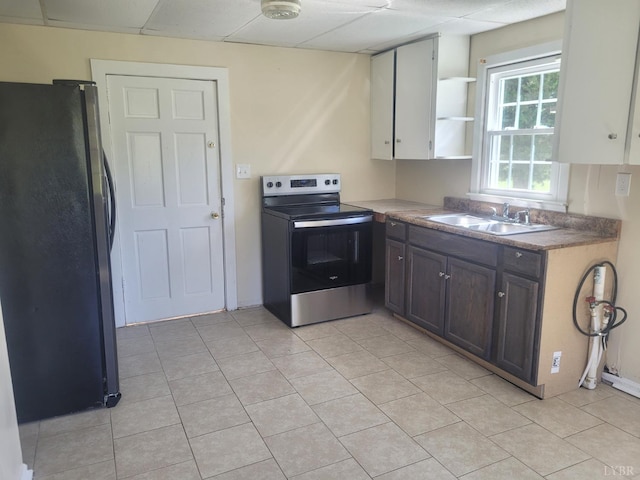 kitchen with open shelves, a sink, light tile patterned flooring, appliances with stainless steel finishes, and a paneled ceiling
