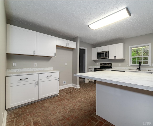108 Trapper Ln, Vinton, VA 24179 - kitchen featuring stainless steel appliances, a sink, light countertops, white cabinets, and a textured ceiling
