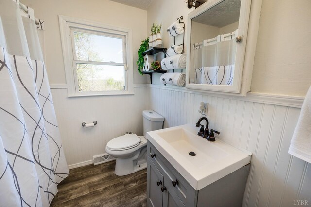 2477 Mountain Rd, Gretna, VA 24557 - bathroom with vanity, visible vents, a wainscoted wall, toilet, and wood finished floors