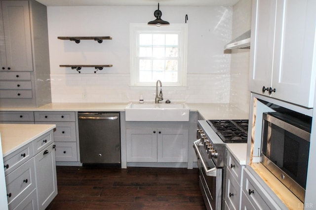 1428 Club Dr, Lynchburg, VA 24503 - kitchen featuring appliances with stainless steel finishes, a sink, under cabinet range hood, dark wood-style flooring, and tasteful backsplash