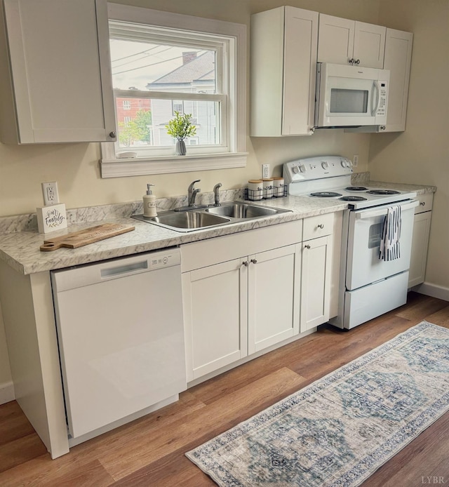 1225 Early St, Lynchburg, VA 24502 - kitchen featuring white appliances, a sink, light wood-style flooring, light countertops, and white cabinets