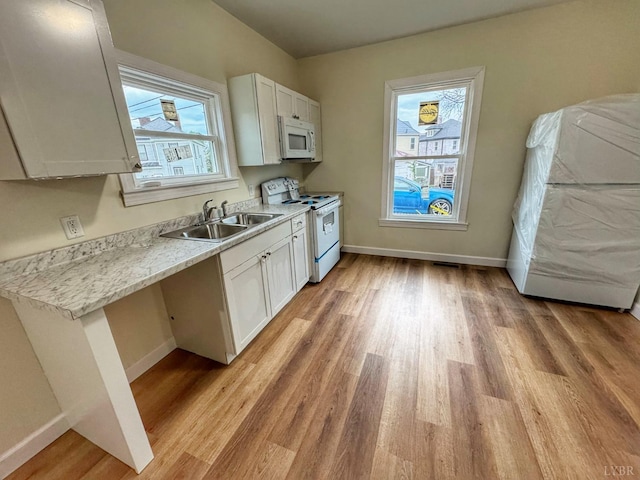 1225 Early St, Lynchburg, VA 24502 - kitchen with white appliances, a sink, baseboards, light wood-type flooring, and plenty of natural light