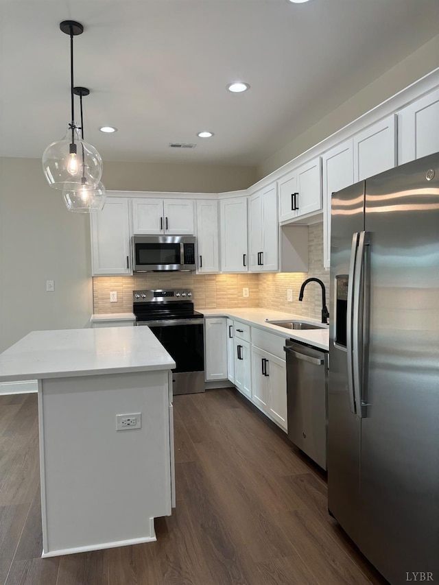 kitchen featuring white cabinets, appliances with stainless steel finishes, a sink, and light countertops