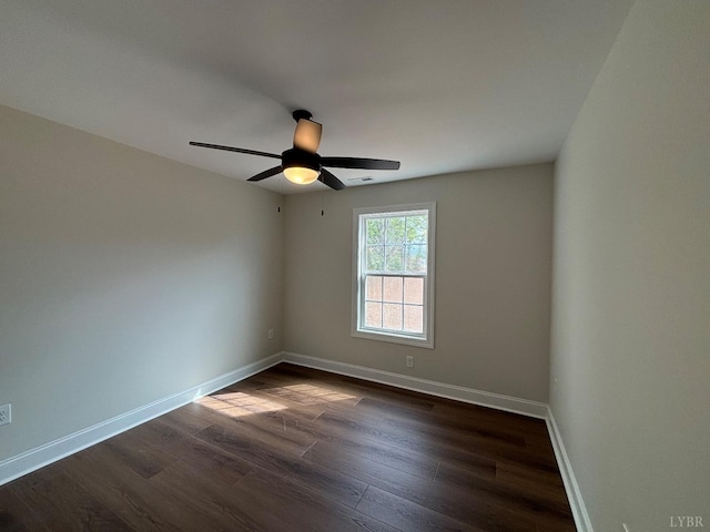 empty room featuring visible vents, a ceiling fan, baseboards, and dark wood-type flooring
