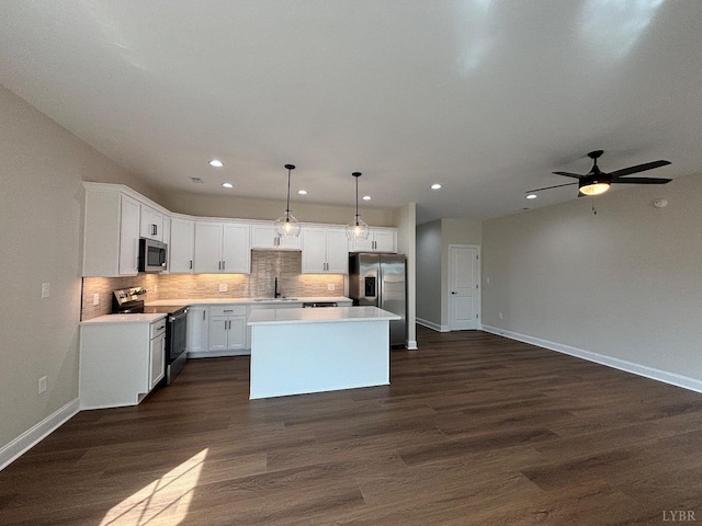 kitchen featuring light countertops, a kitchen island, backsplash, and appliances with stainless steel finishes