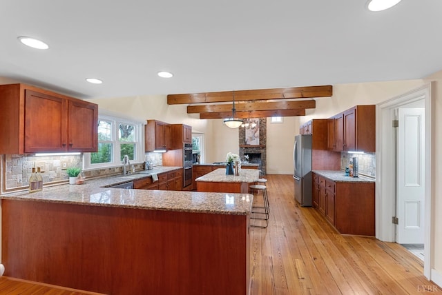 281 Calohan Rd, Rustburg, VA 24588 - kitchen featuring a peninsula, light wood-style flooring, light stone counters, and appliances with stainless steel finishes