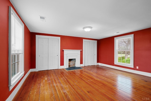 281 Calohan Rd, Rustburg, VA 24588 - unfurnished living room featuring a fireplace with flush hearth, wood-type flooring, visible vents, and baseboards