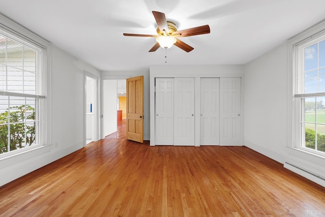 281 Calohan Rd, Rustburg, VA 24588 - unfurnished bedroom featuring baseboard heating, light wood-type flooring, ceiling fan, and two closets
