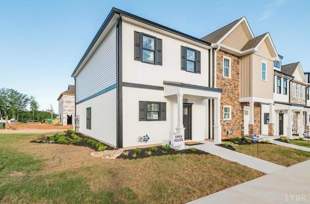 view of front of property featuring stone siding and a front lawn