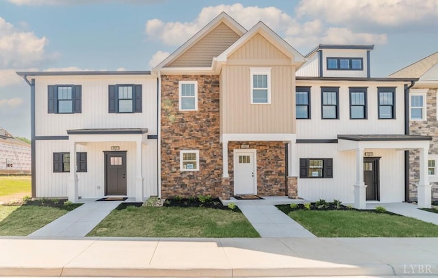 multi unit property featuring stone siding and a front yard
