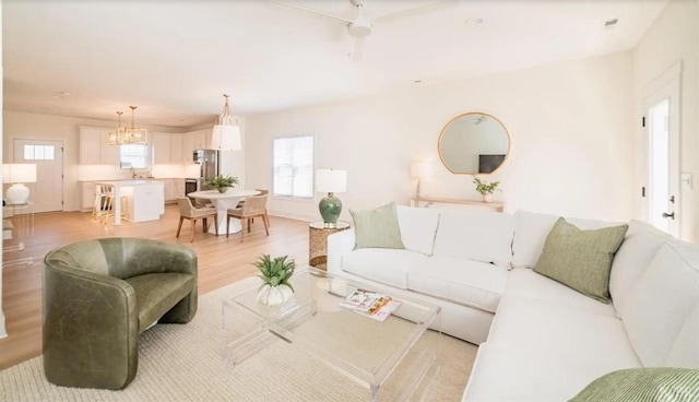 living room featuring a chandelier and light wood-type flooring
