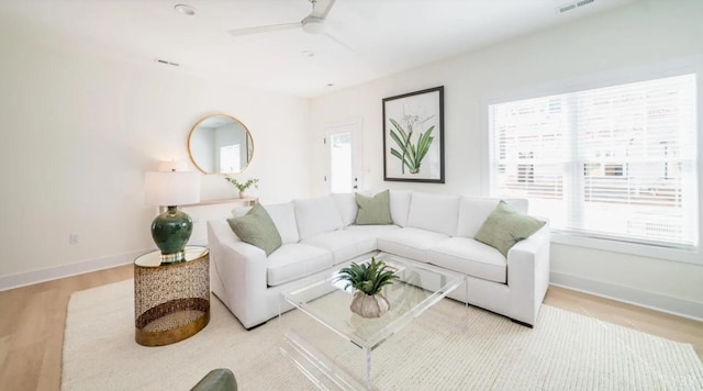 living room with ceiling fan, a wealth of natural light, wood finished floors, and baseboards
