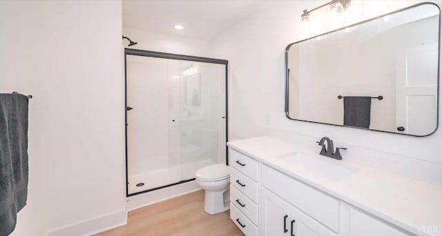 full bath with recessed lighting, wood finished floors, toilet, vanity, and a stall shower