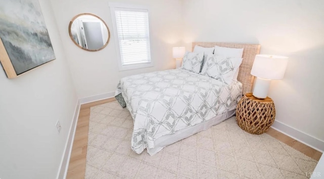 bedroom with wood finished floors and baseboards