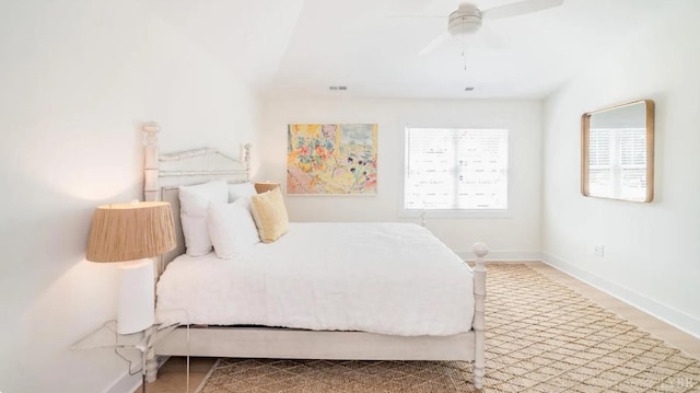 bedroom featuring baseboards, wood finished floors, visible vents, and ceiling fan