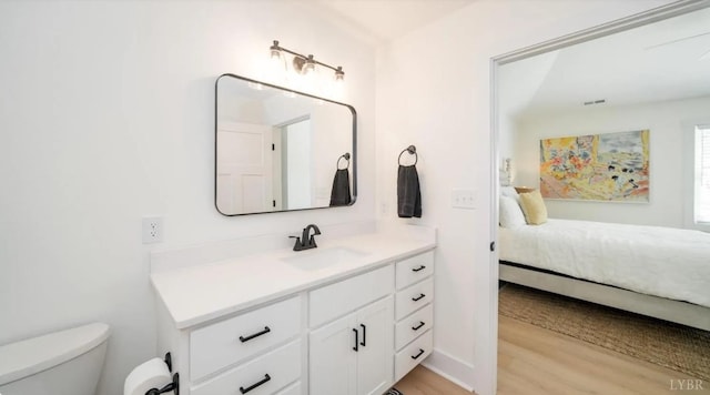 ensuite bathroom with wood finished floors, visible vents, toilet, vanity, and ensuite bathroom
