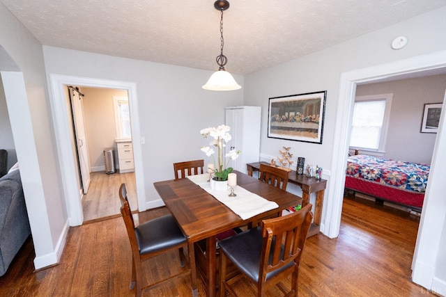 299 Alum Springs Rd, Lynchburg, VA 24502 - dining room featuring light wood-style flooring, a textured ceiling, baseboards, and arched walkways