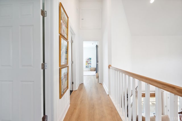 corridor with a wealth of natural light, light wood-style flooring, and baseboards