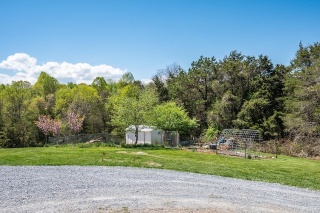 view of yard with a garden, fence, and an outbuilding