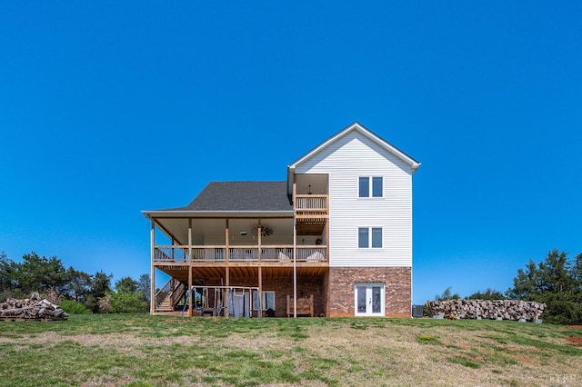 rear view of house featuring stairs, french doors, brick siding, and a lawn