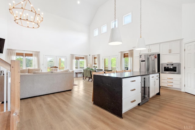 kitchen featuring dark countertops, wine cooler, high vaulted ceiling, and a healthy amount of sunlight