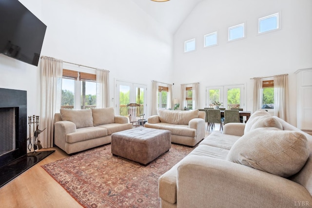 living room featuring a healthy amount of sunlight, high vaulted ceiling, and wood finished floors