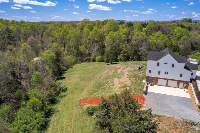birds eye view of property featuring a forest view