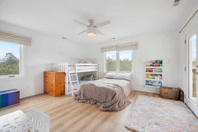 bedroom with multiple windows, wood finished floors, baseboards, and ceiling fan