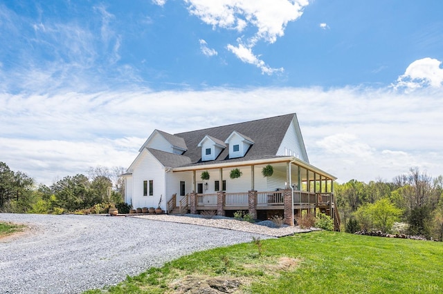 view of front facade featuring covered porch, driveway, and a front lawn