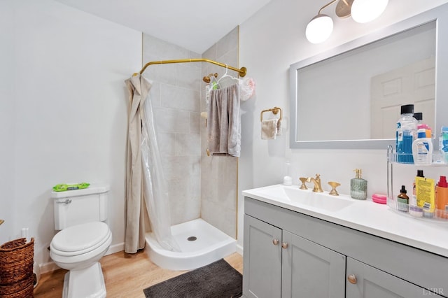 full bathroom with vanity, toilet, wood finished floors, and a shower stall