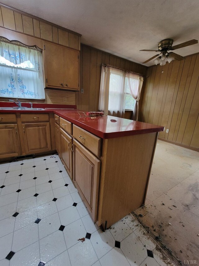 1418 Mitchell Rd, Chatham, VA 24531 - kitchen with ceiling fan, dark countertops, a peninsula, brown cabinets, and wood walls