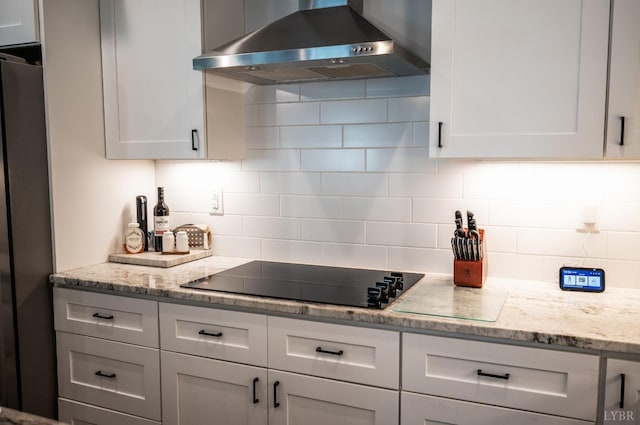 1033 Elk Creek Rd, Forest, VA 24551 - kitchen with wall chimney range hood, black electric stovetop, freestanding refrigerator, and decorative backsplash