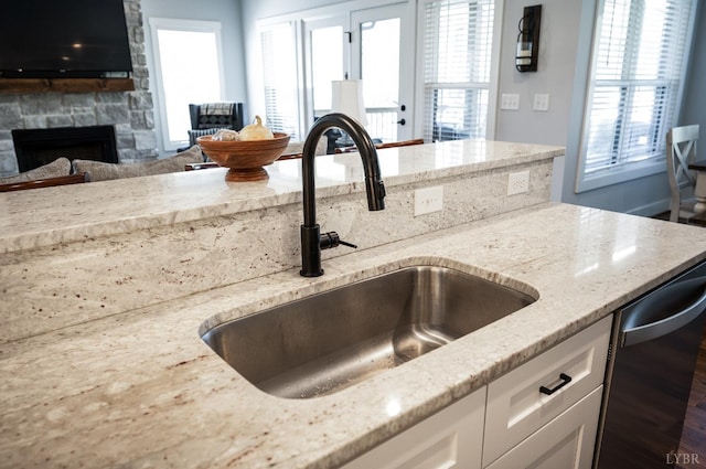 1033 Elk Creek Rd, Forest, VA 24551 - kitchen with a sink, light stone counters, open floor plan, white cabinetry, and a stone fireplace