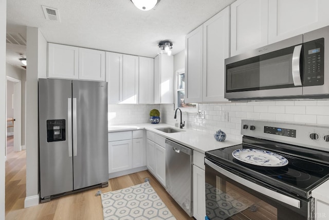 442 W King St, Bedford, VA 24523 - kitchen with white cabinets, a sink, and appliances with stainless steel finishes