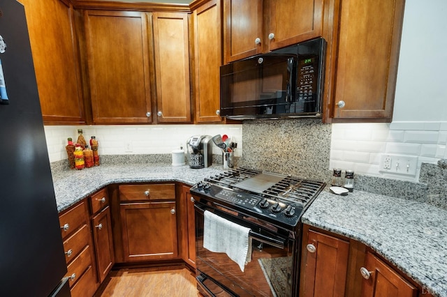 328 Paulette Cir, Lynchburg, VA 24502 - kitchen featuring black appliances, backsplash, light stone countertops, and brown cabinets