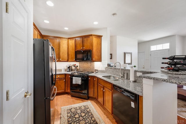 328 Paulette Cir, Lynchburg, VA 24502 - kitchen with black appliances, a sink, a peninsula, light wood-type flooring, and light stone countertops