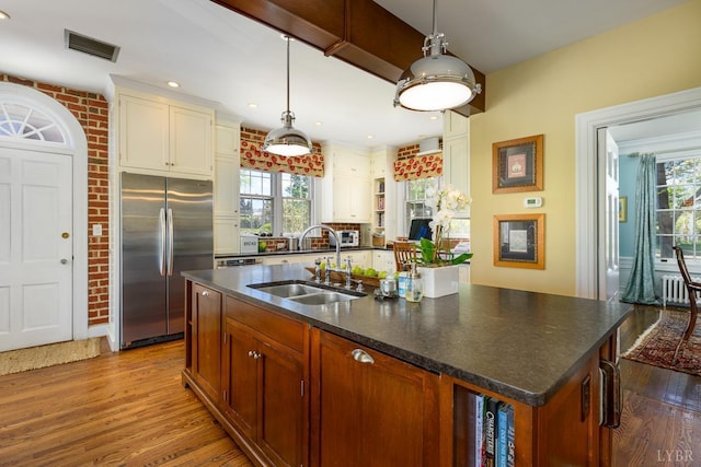 3830 Peakland Pl, Lynchburg, VA 24503 - kitchen with stainless steel fridge, wood finished floors, an island with sink, a sink, and radiator heating unit