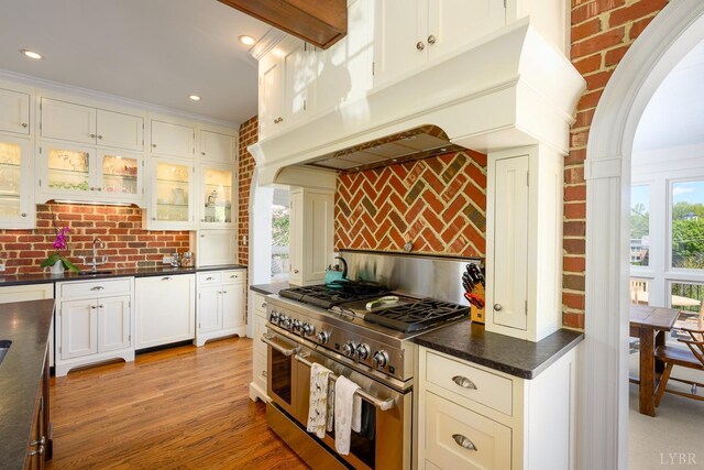 3830 Peakland Pl, Lynchburg, VA 24503 - kitchen featuring glass insert cabinets, range with two ovens, paneled dishwasher, dark countertops, and tasteful backsplash